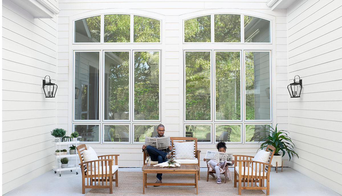 Man and daughter sitting outside their beautiful Pella replacement windows