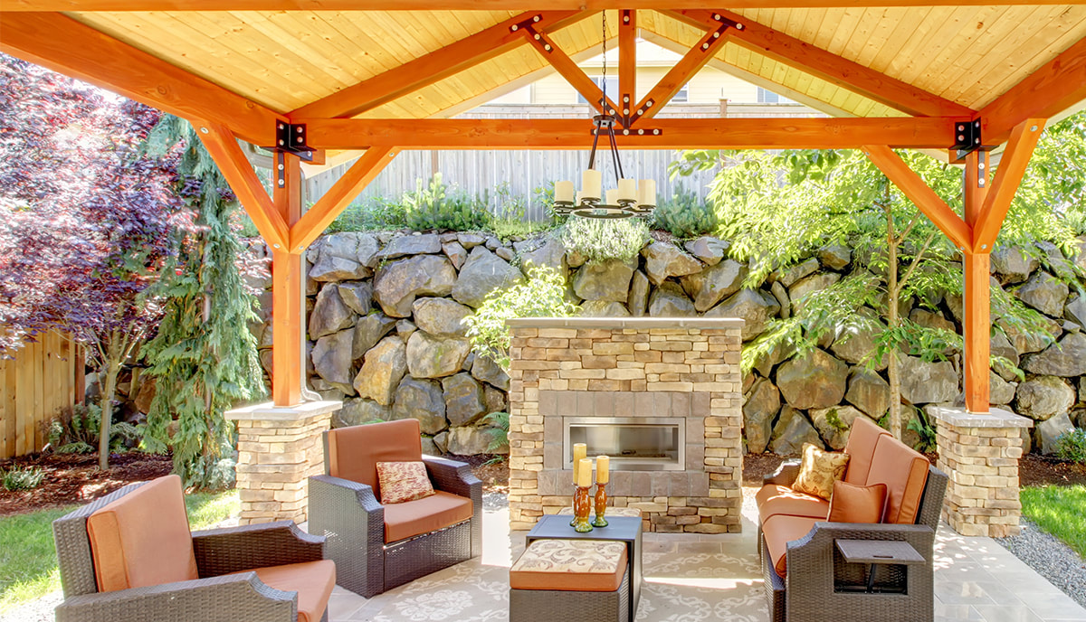 Exterior covered patio with fireplace and furniture